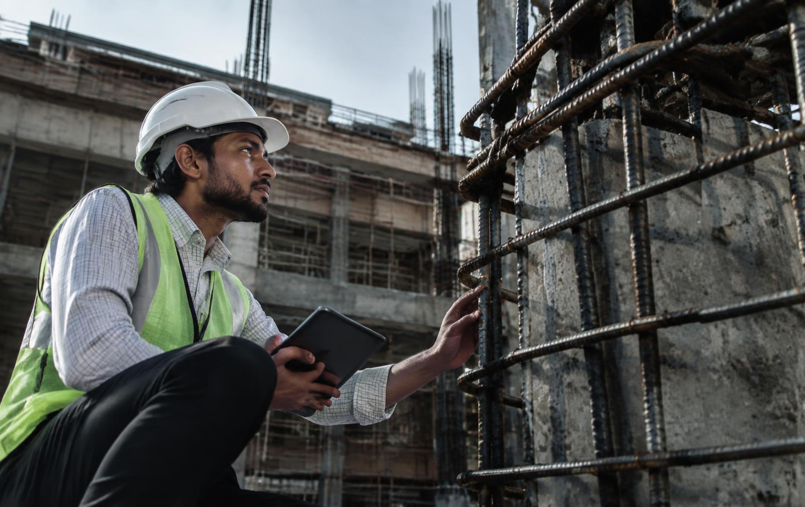 Site engineer inspecting steel reinforcement on a construction site
